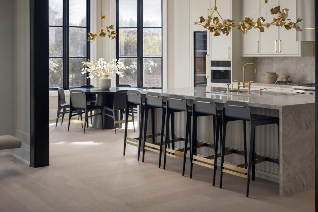 A luxurious modern kitchen with a marble island and gold-accent lighting, photographed by a Toronto interior photographer showcasing refined design elements.